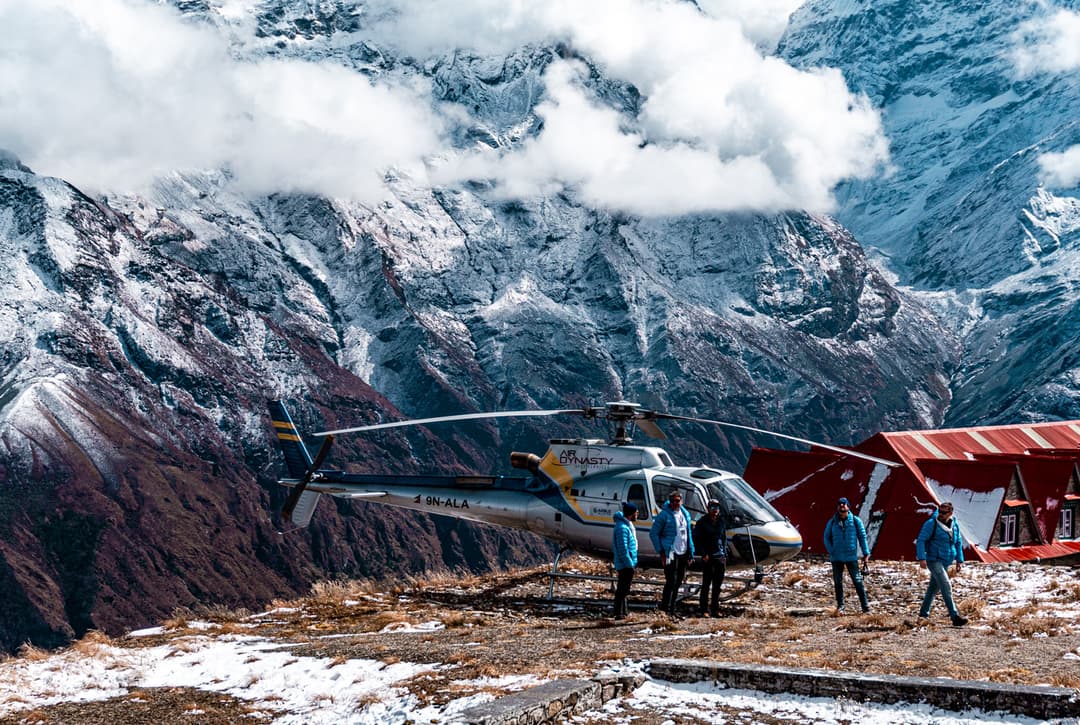 Private helicopter landing at Kongde Resort with snow-capped Himalayan peaks in the background