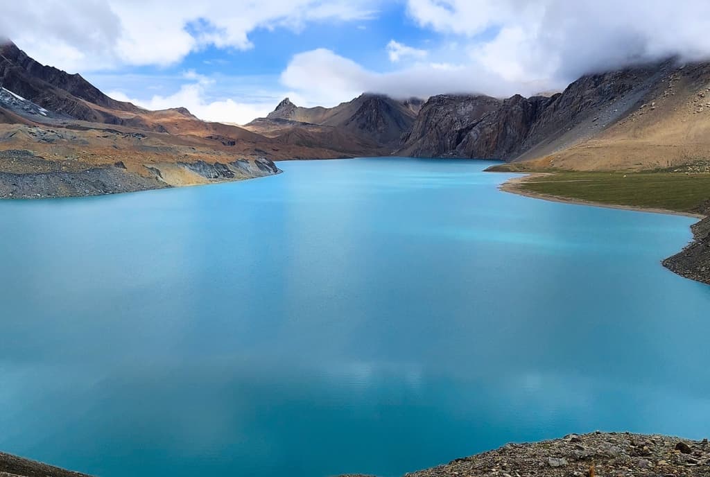 Blue Tilicho Lake Trek surrounded by mountains in Nepal