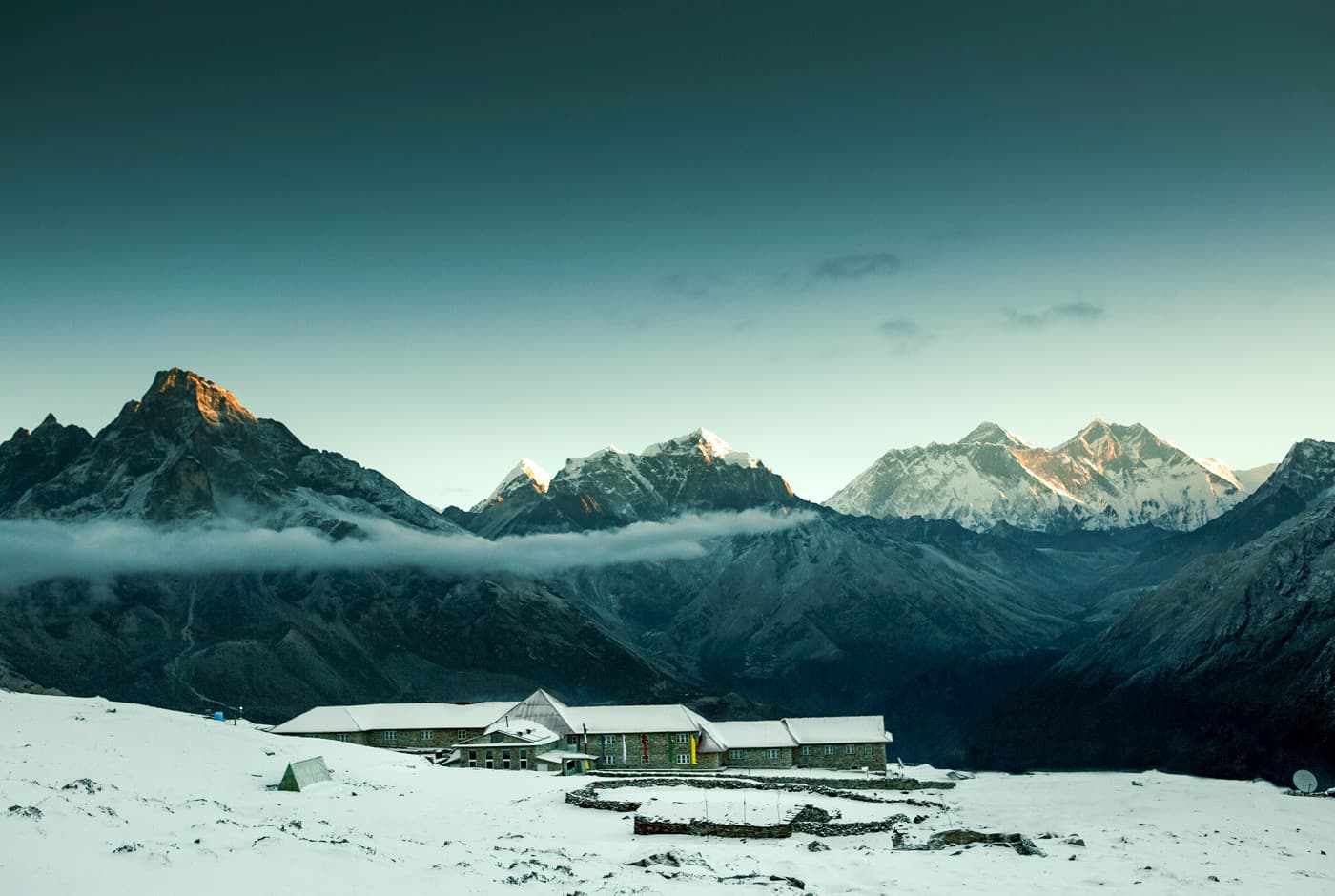 Stone Lodge At 4,250m With Snowy Everest Range And Peaks Under A Clear Blue Sky.
